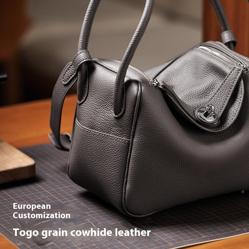 Black leather handbag on a cutting mat with 'European Customization' text