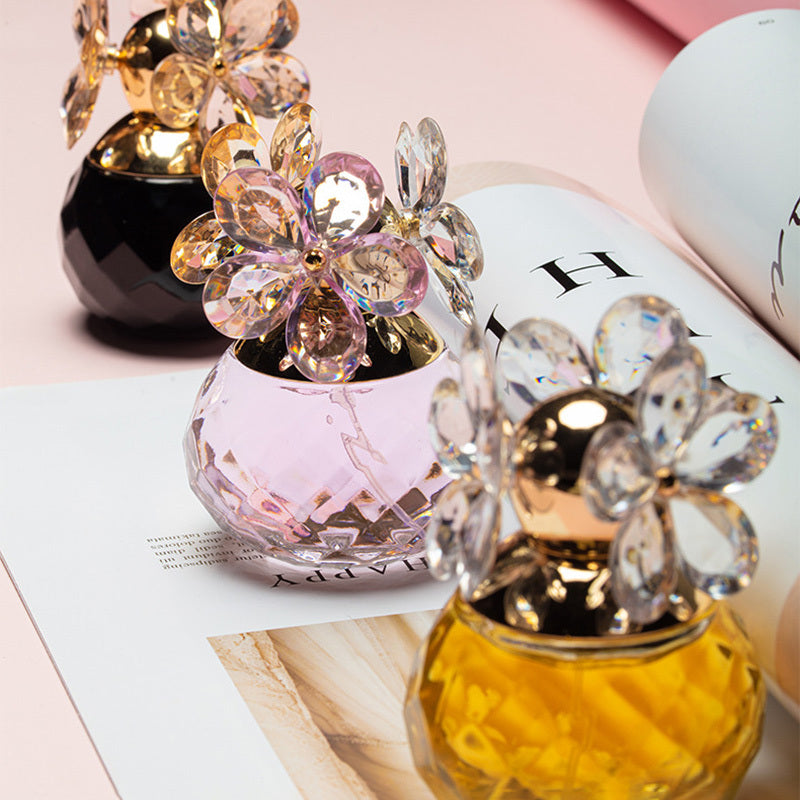 Two decorative perfume bottles with crystal designs on a magazine