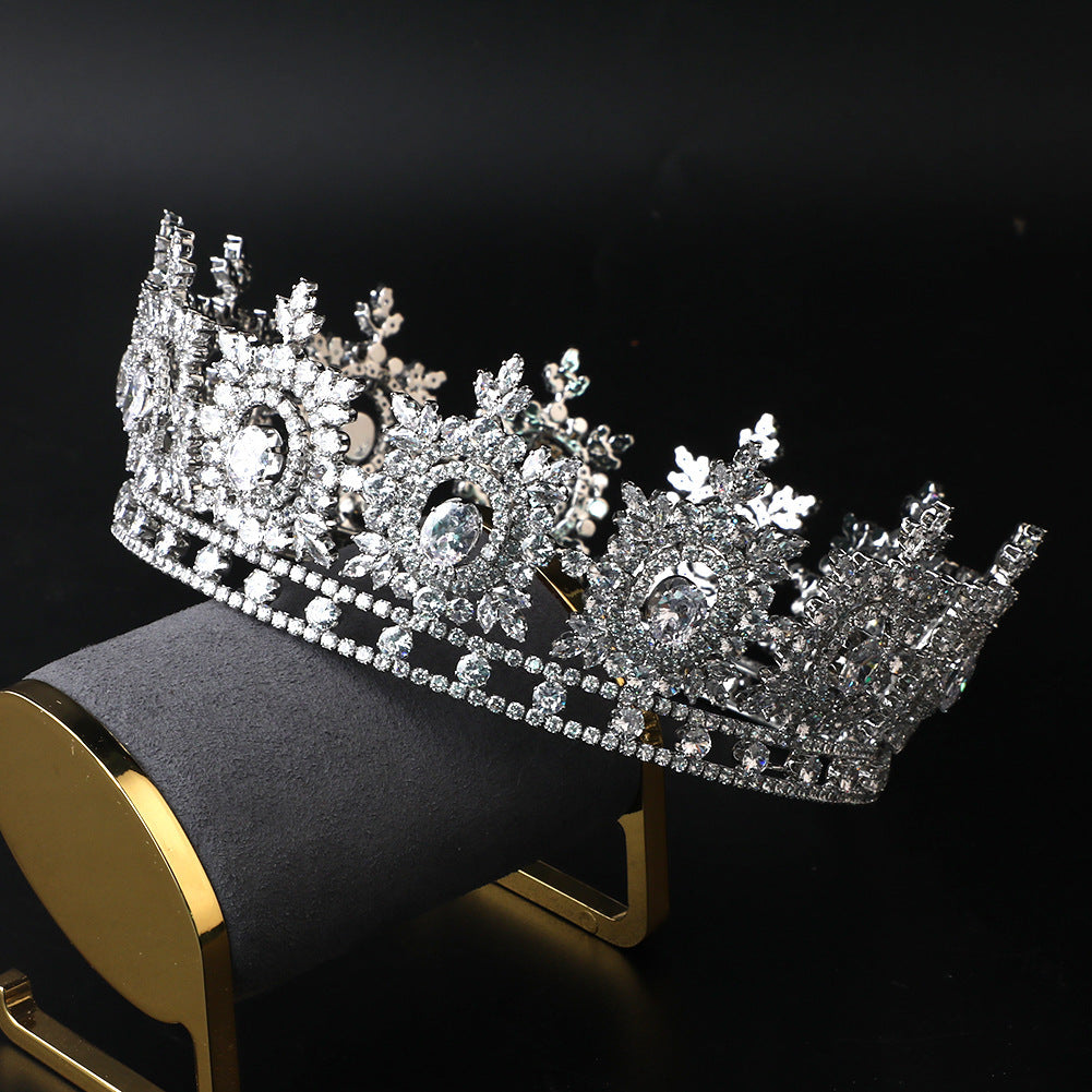 Silver tiara with intricate design on a black background