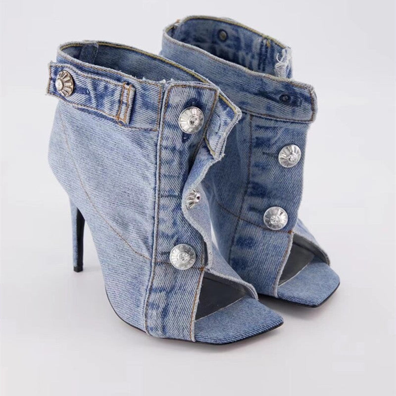 Denim high-heeled shoes with silver buttons on a white background