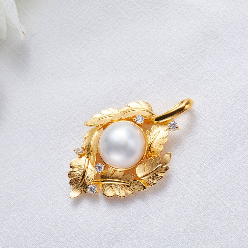 Gold pendant with a pearl and small diamonds on a white background