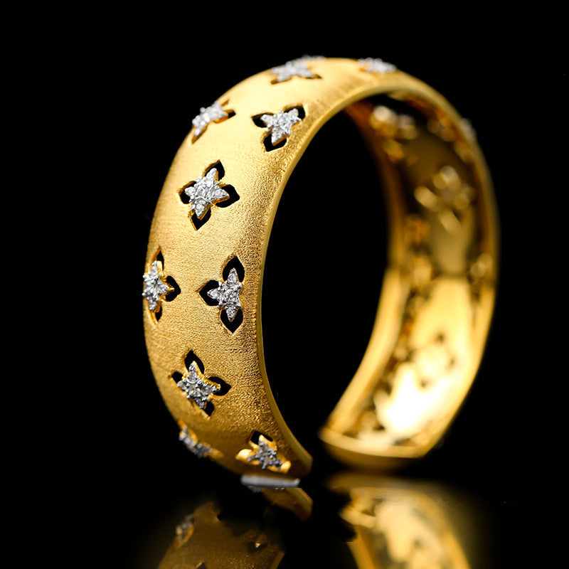Gold ring with diamond accents on a black background