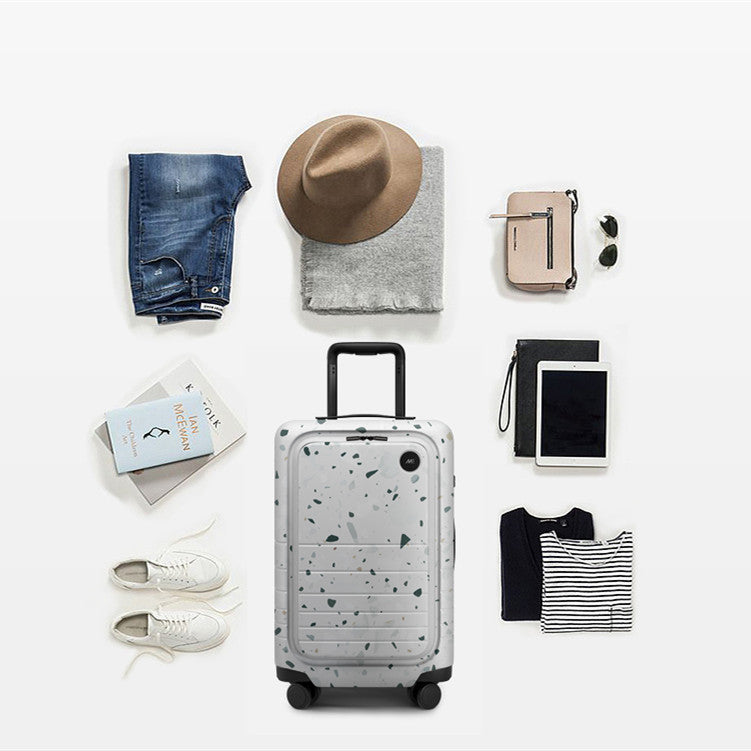 Collection of travel items including a suitcase, clothing, and accessories on a white background