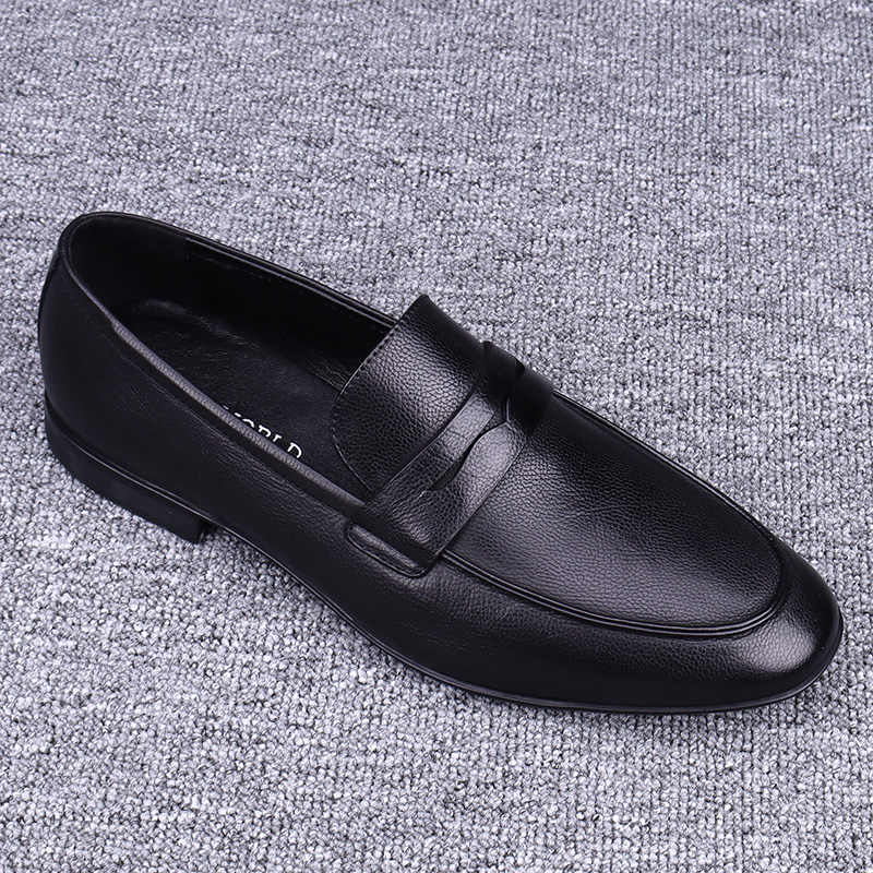 Black leather loafer shoe on a textured gray background
