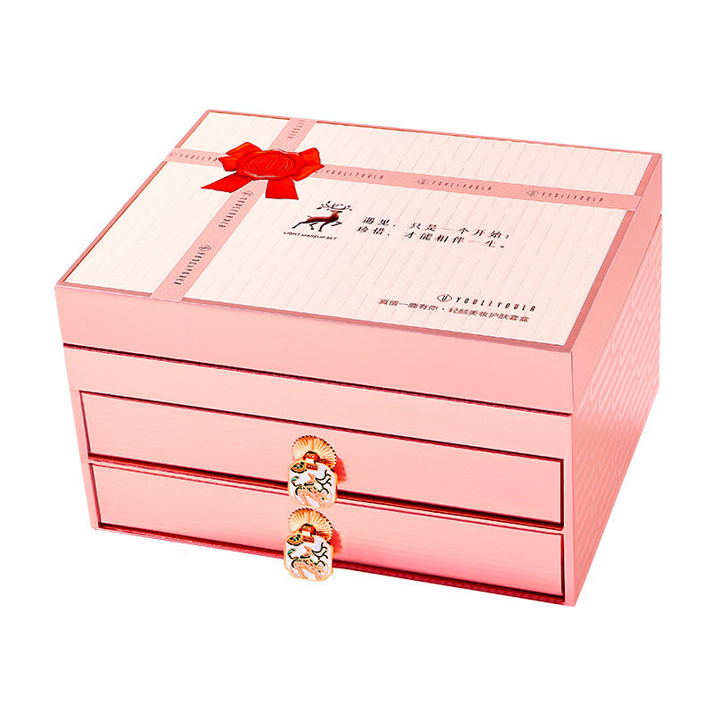 Pink jewelry box with a bow and bracelet on a white background