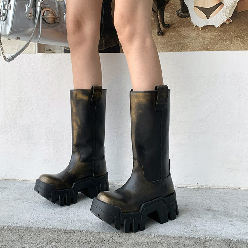 Black platform boots worn by a person on a light gray floor.