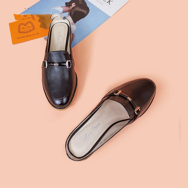 Pair of black loafers on a peach background