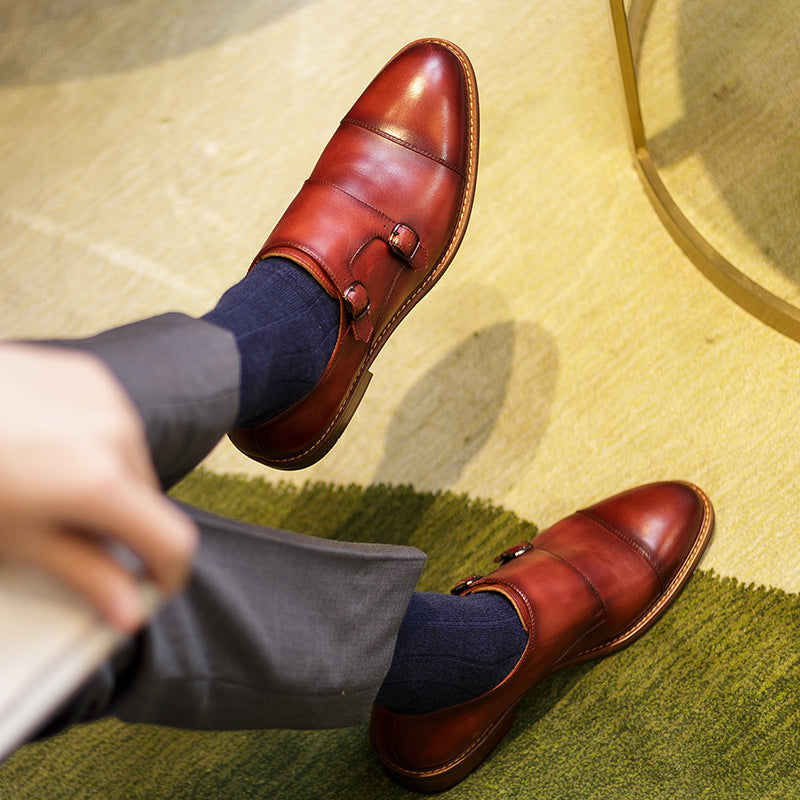 Brown leather shoes with navy socks on a green rug