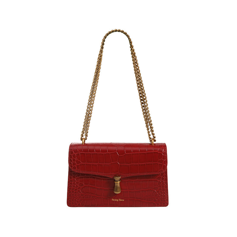 Red handbag with gold chain strap on a white background