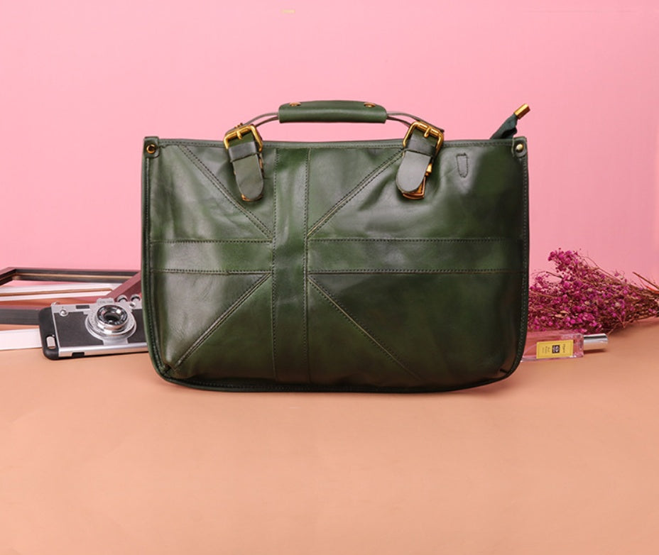 Green leather bag on a pink and beige gradient background with a camera and flowers.