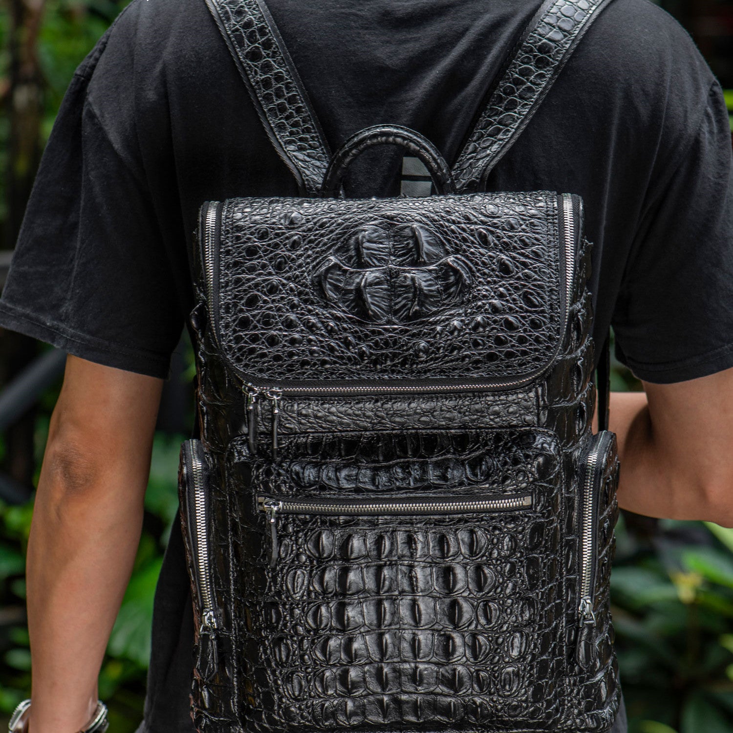 Person wearing a black textured backpack with a brand logo.