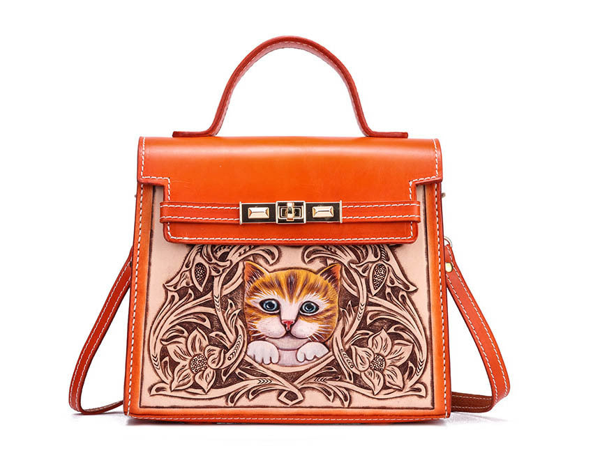 Orange handbag with a cat design on a white background