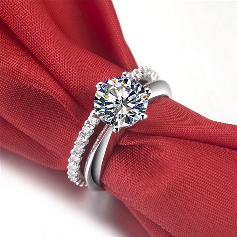Silver ring with a large diamond on a red fabric background