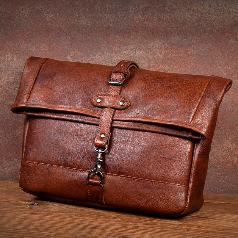 Brown leather bag with strap on a wooden surface and brown background