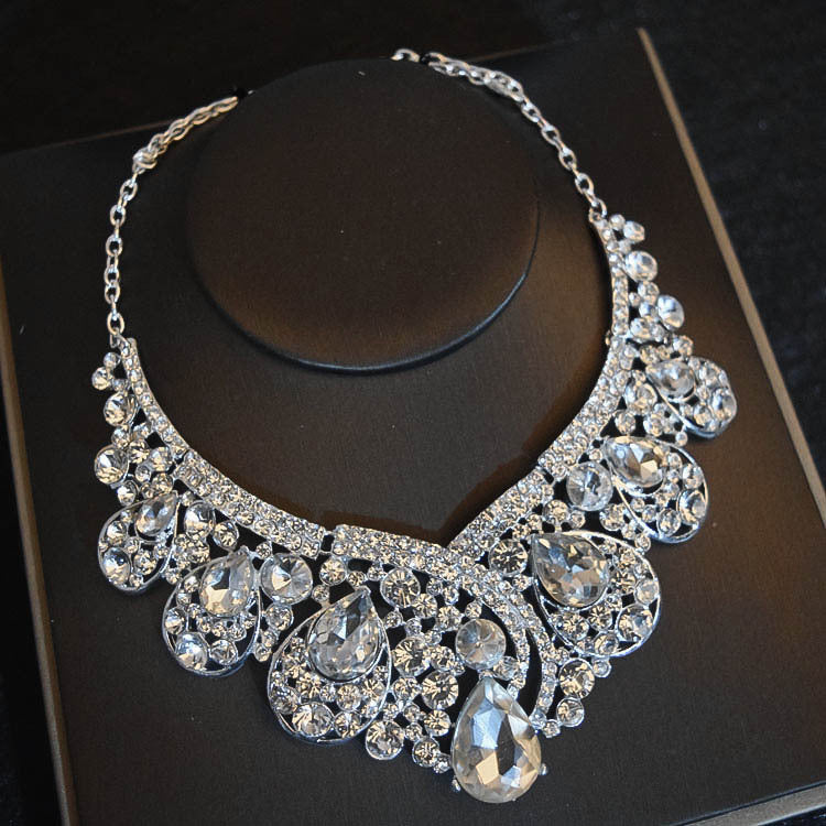 Elegant silver necklace with clear stones on a dark surface
