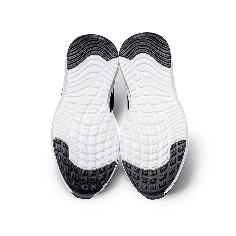 White athletic shoes with black soles on a white background