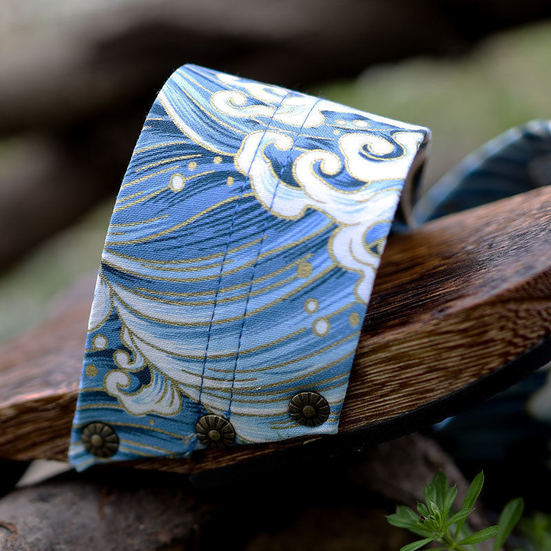Decorative blue and white patterned object on a wooden surface with a natural background