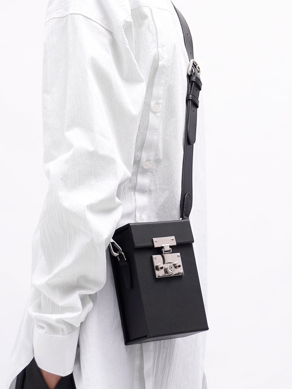 Black handbag with silver clasp on a white background