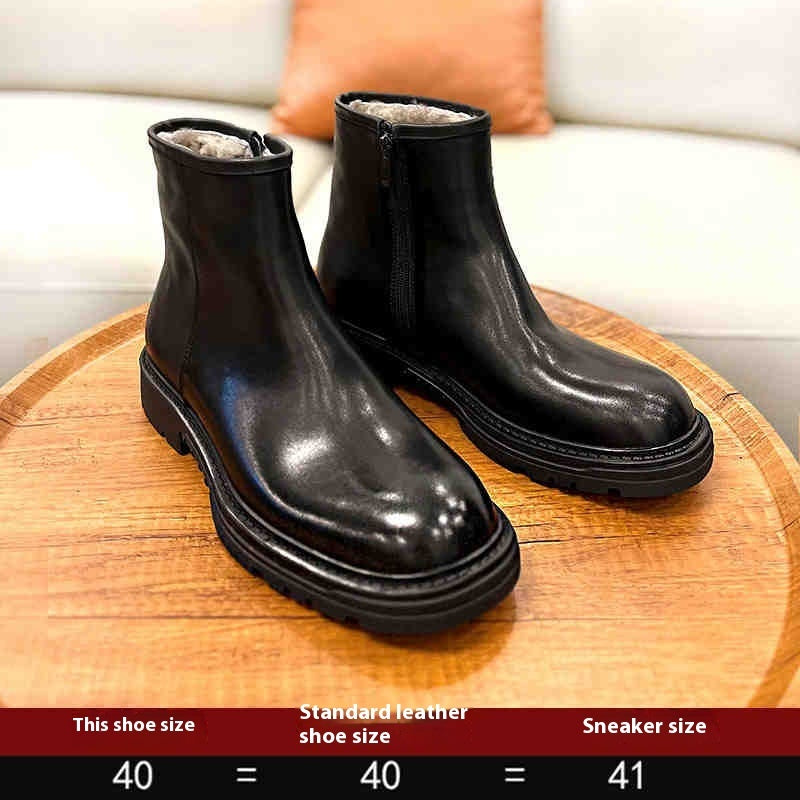 Pair of black leather boots on a wooden surface with a blurred background