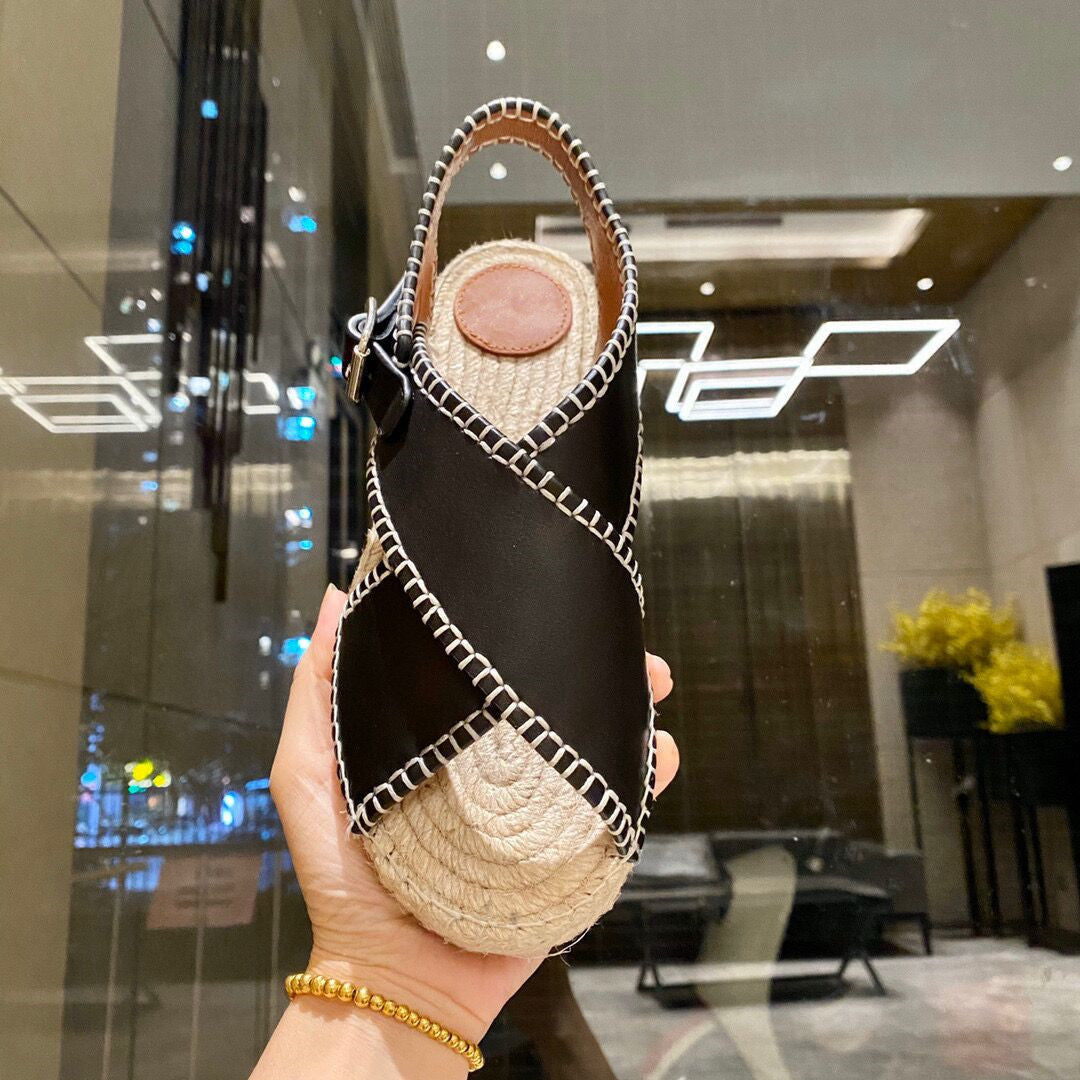Handheld black and beige woven bag with a textured handle in an indoor setting.