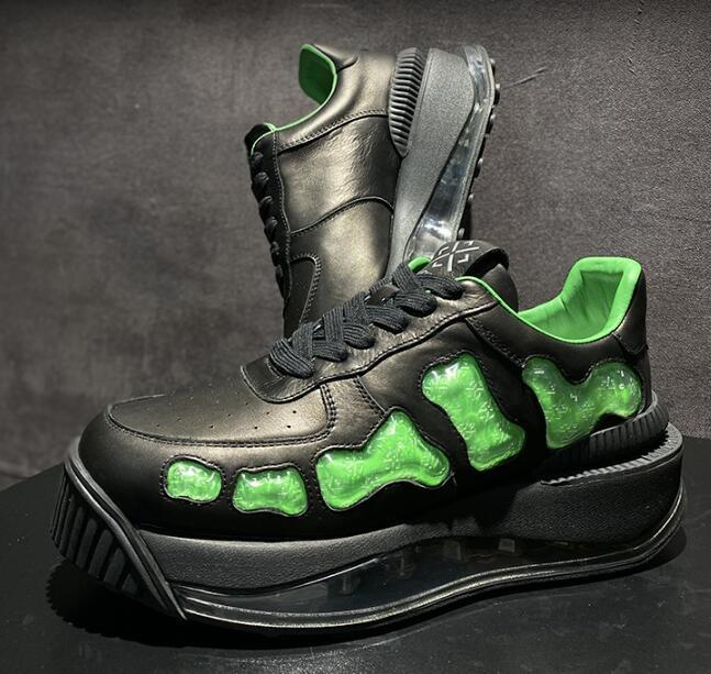 Black sneakers with green accents on a dark background