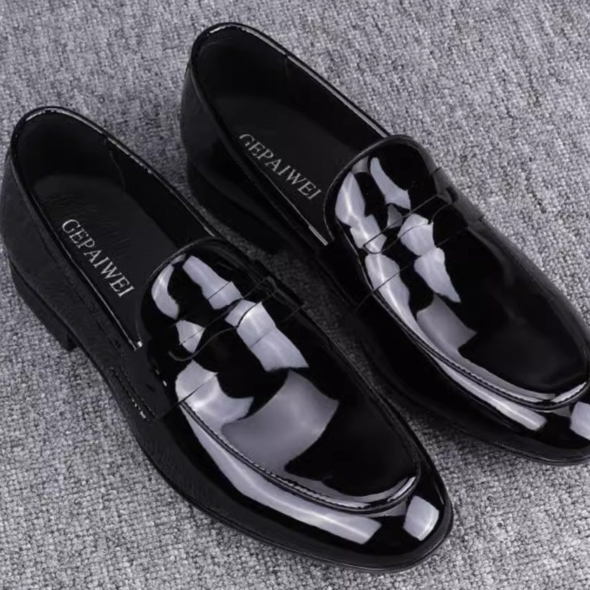 Black glossy loafers with 'GEPAIWEI' branding on a gray textured background