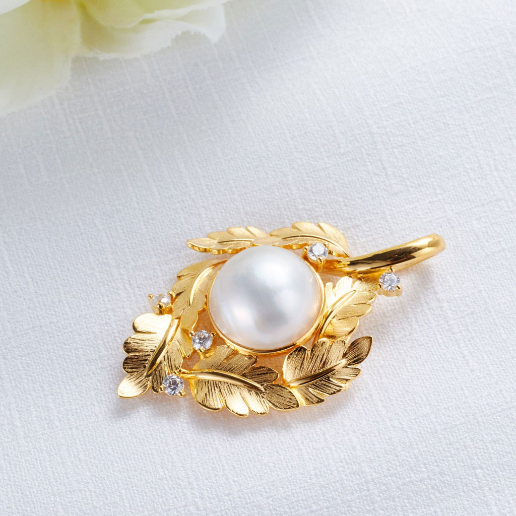 Gold pendant with a pearl on a white background