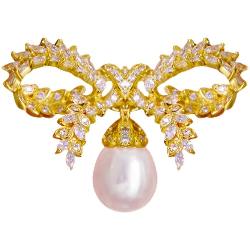 Gold brooch with pearl on a white background