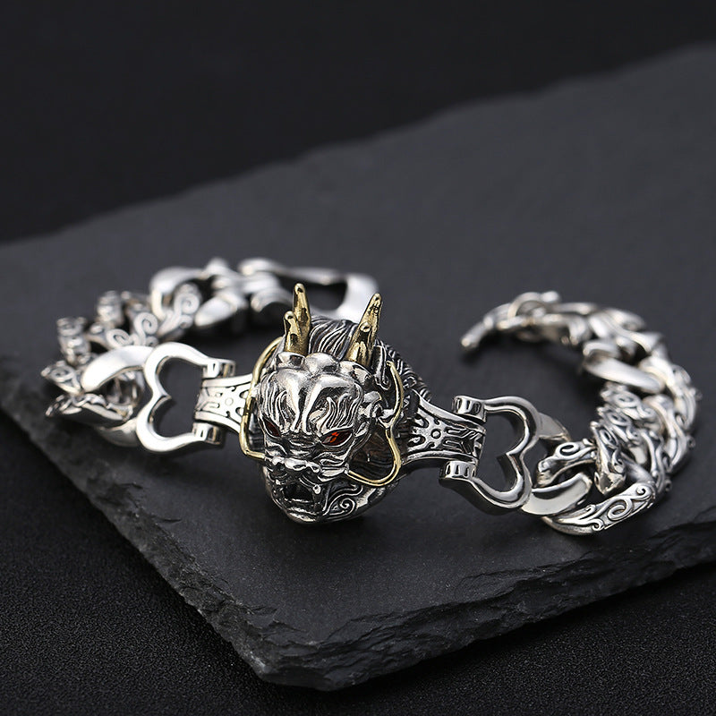 Silver bracelet with dragon design on a dark surface