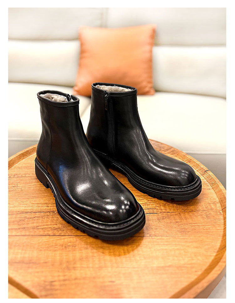 Black shiny boots on a wooden surface with a neutral background
