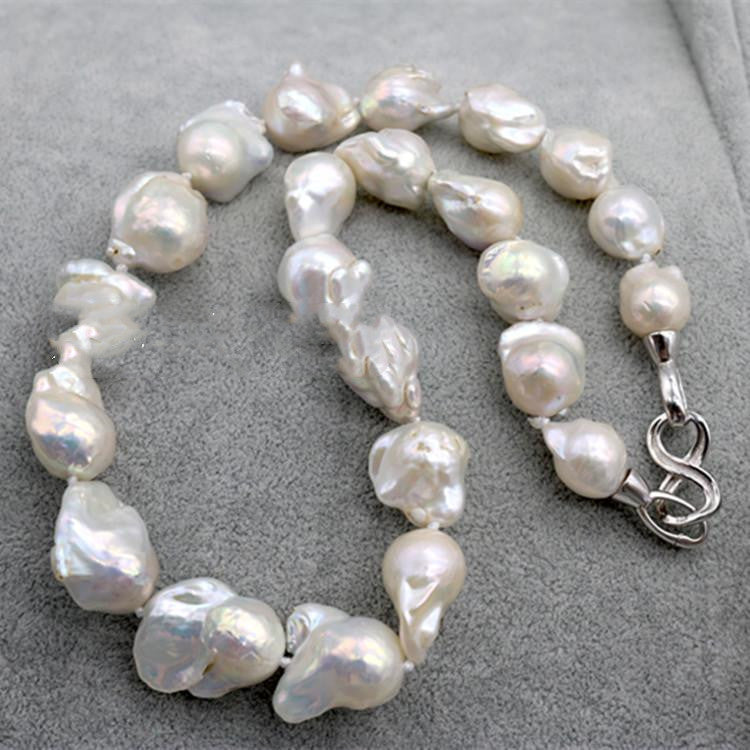 Pearl necklace with a silver clasp on a gray surface