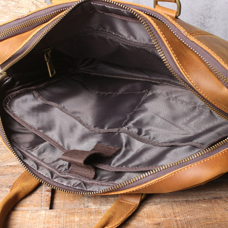 Brown leather bag with open interior on a wooden surface