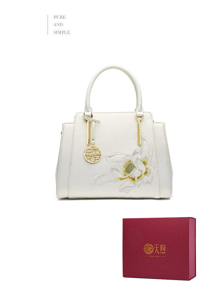 White handbag with floral design and matching box on a white background