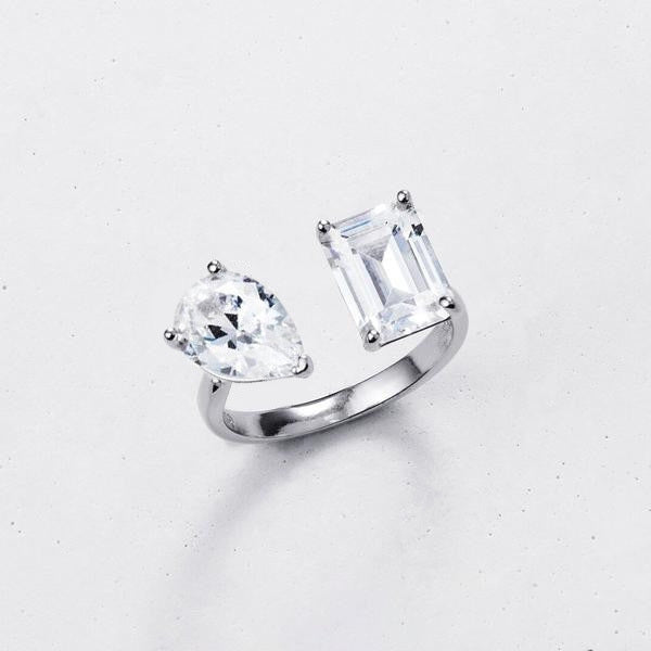 Silver ring with two large clear gemstones on a light gray background