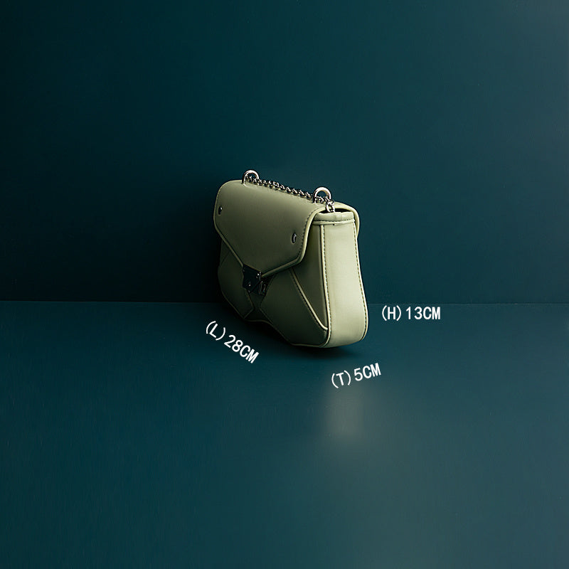 Green handbag with measurements on a dark background