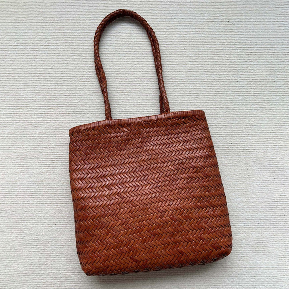 Brown woven handbag on a light gray background