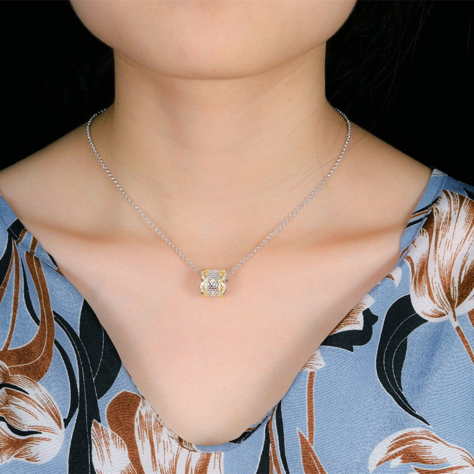 Necklace with a floral pendant worn by a person against a floral-patterned fabric background