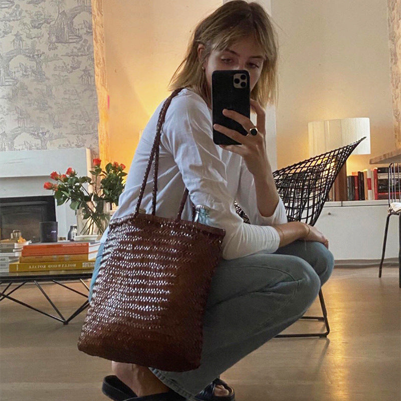 Woman taking a selfie in a living room with a woven bag