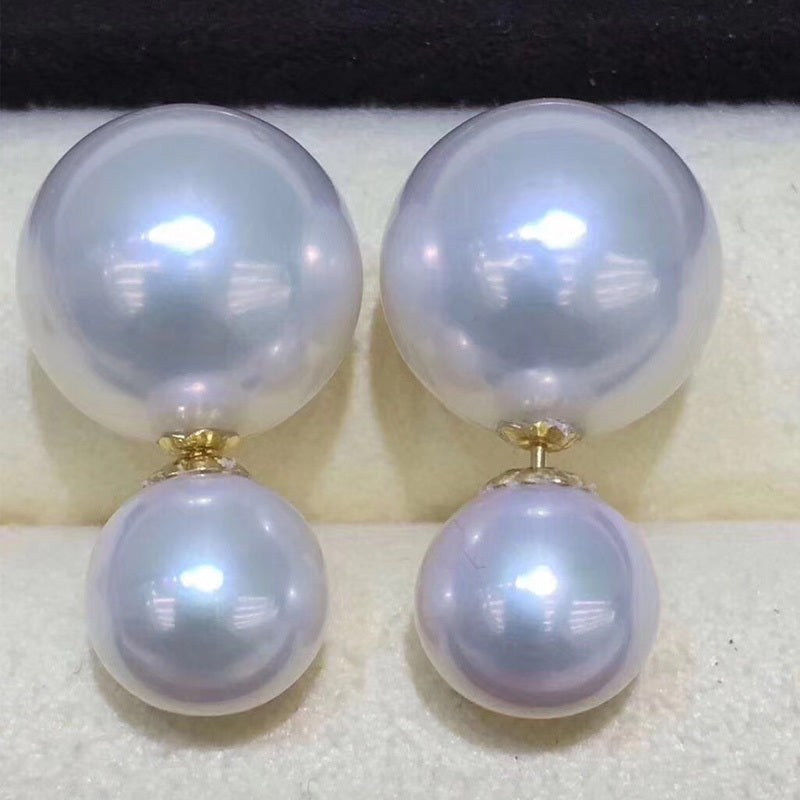 Pair of pearl earrings with gold clasps on a white surface