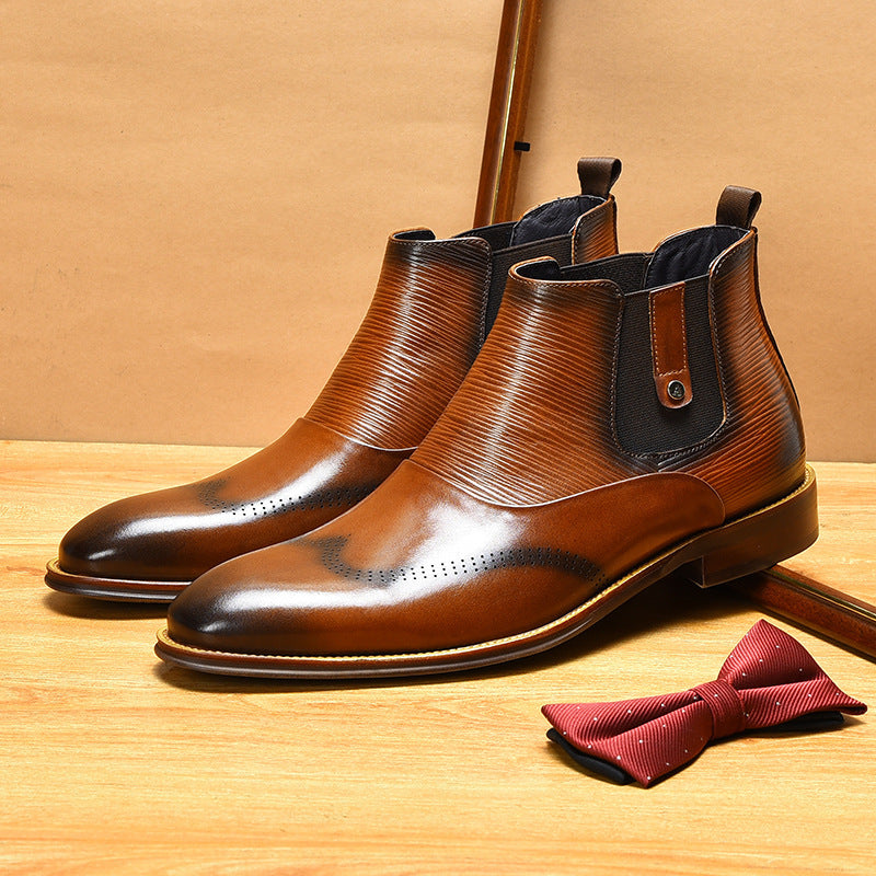 Pair of brown leather boots with black accents on a wooden surface, accompanied by a red bow tie.