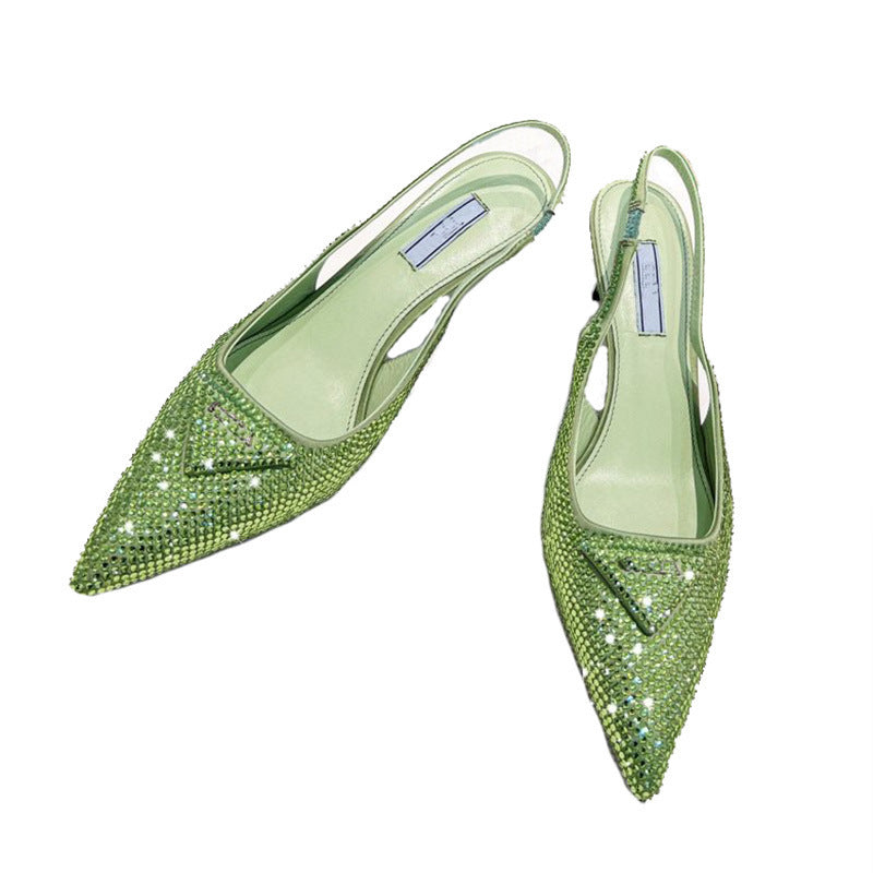 Pair of green pointed-toe shoes with rhinestone embellishments on a white background