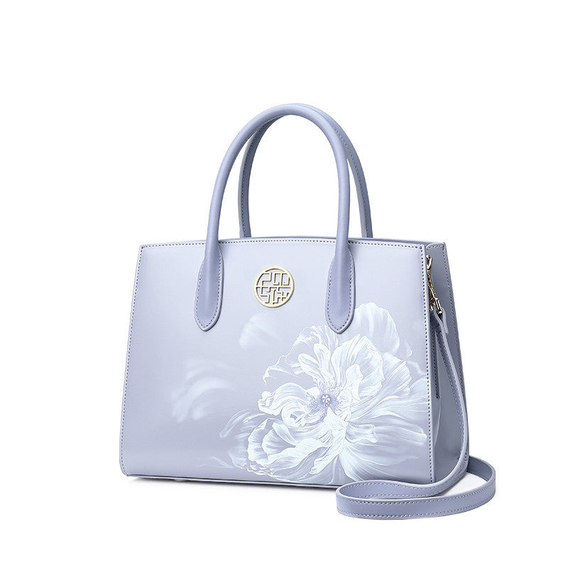 Light blue handbag with floral design on a white background