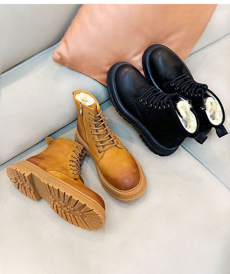 Pair of brown and black boots on a light gray surface