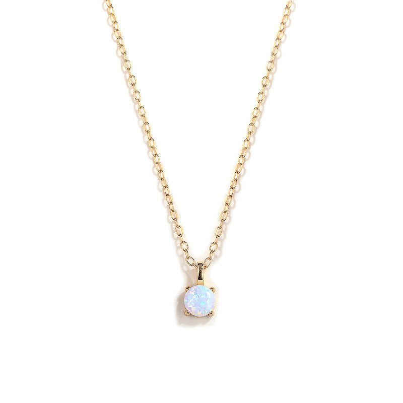 Gold necklace with a small opal pendant on a white background