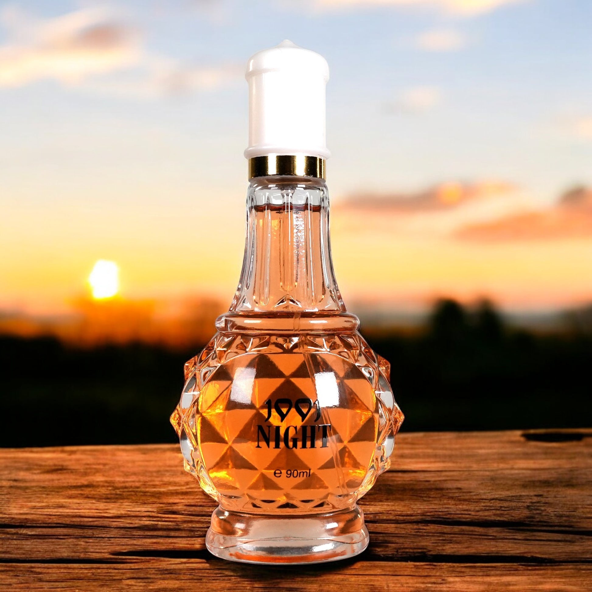 Perfume bottle labeled 'Good Night' on a wooden surface with a sunset background