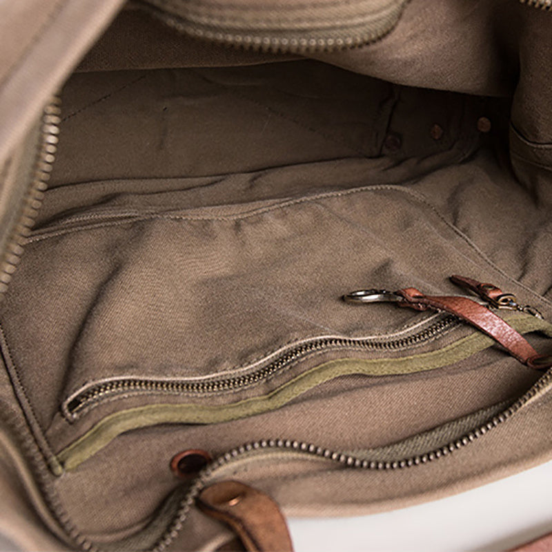 Close-up of a brown leather bag with zippers and stitching details.