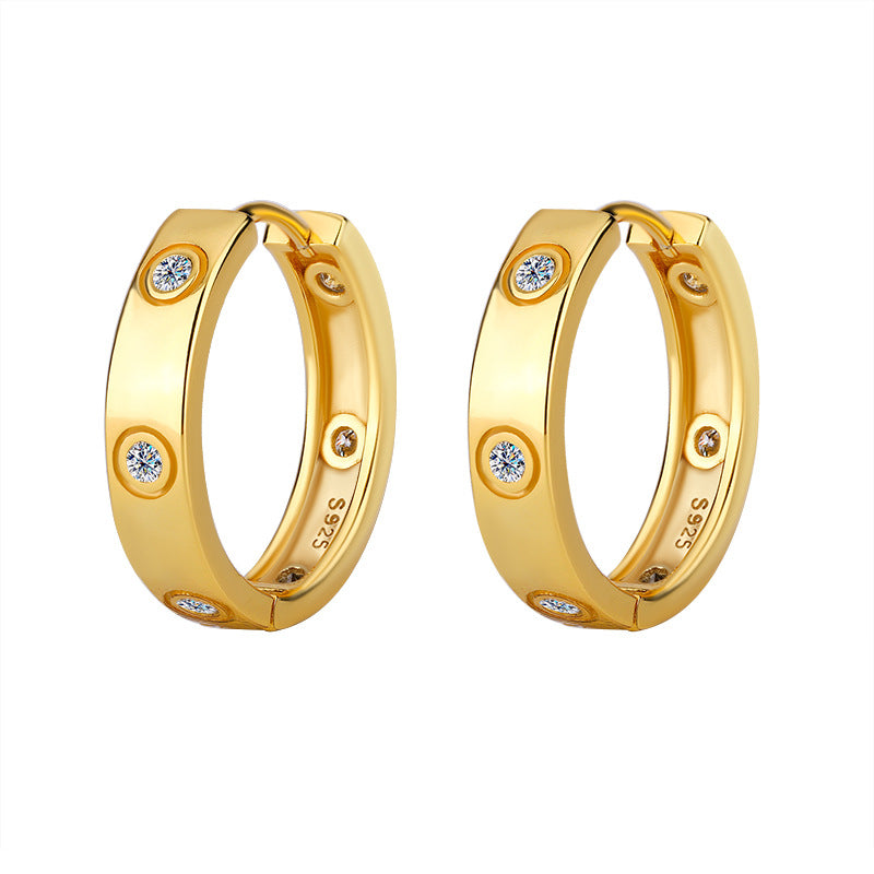 Gold hoop earrings with embedded diamonds on a white background