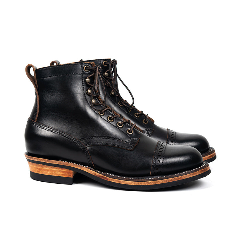 Pair of black leather boots with brown soles on a white background