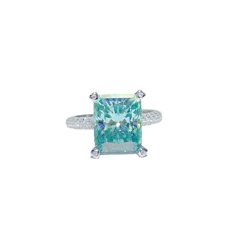 Teal gemstone ring with silver prongs on a white background