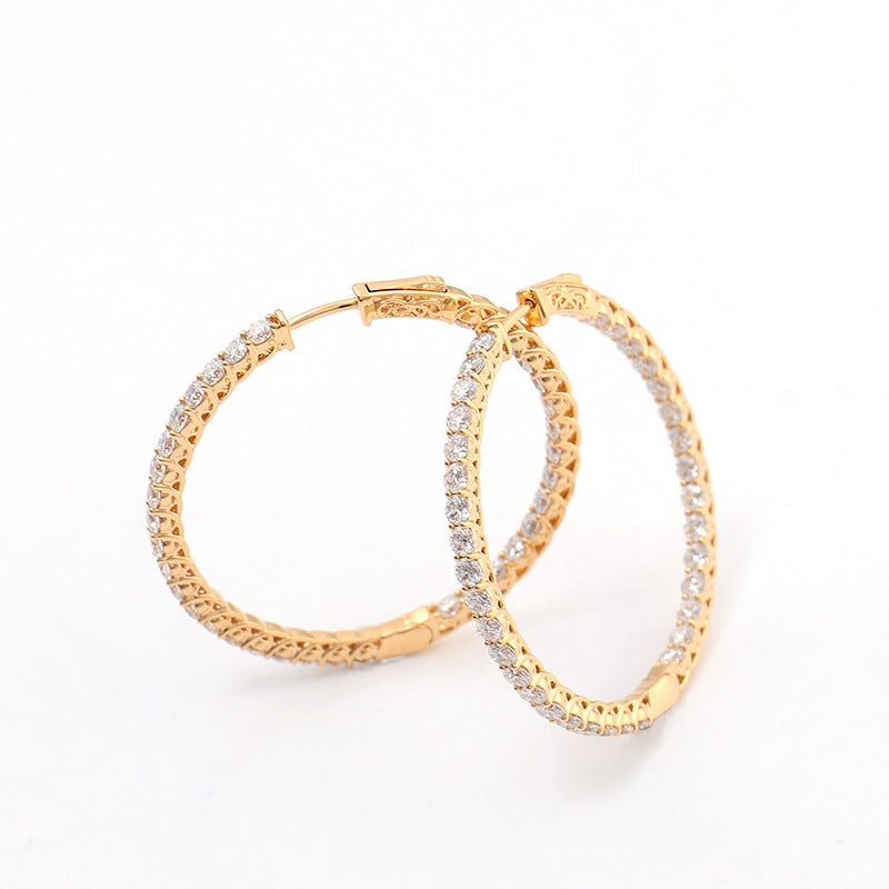Gold hoop earrings with embedded stones on a white background